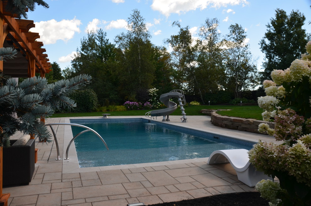 Esempio di un'ampia piscina monocorsia chic rettangolare dietro casa con pavimentazioni in cemento e una dépendance a bordo piscina