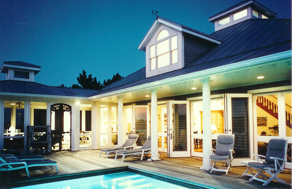 Aménagement d'une grande piscine arrière et hors-sol classique rectangle avec une terrasse en bois et un bain bouillonnant.