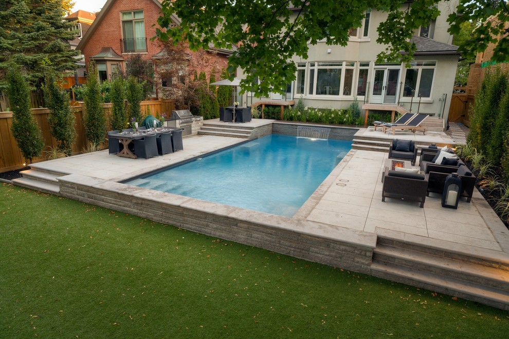 Inspiration for a large contemporary back rectangular lengths swimming pool in Toronto with stamped concrete.