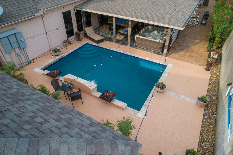 Cette photo montre une piscine arrière tendance de taille moyenne et rectangle avec un bain bouillonnant et du béton estampé.