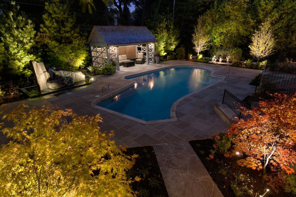 Diseño de casa de la piscina y piscina natural tradicional renovada de tamaño medio a medida en patio trasero con adoquines de piedra natural