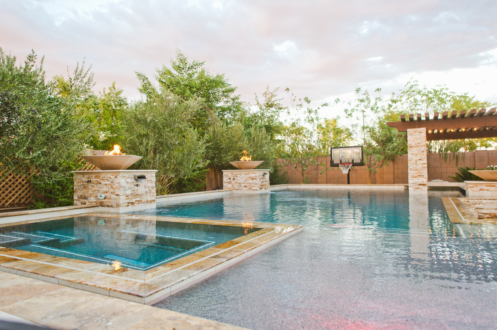 На фото: большой бассейн-инфинити произвольной формы на заднем дворе в современном стиле с покрытием из каменной брусчатки с