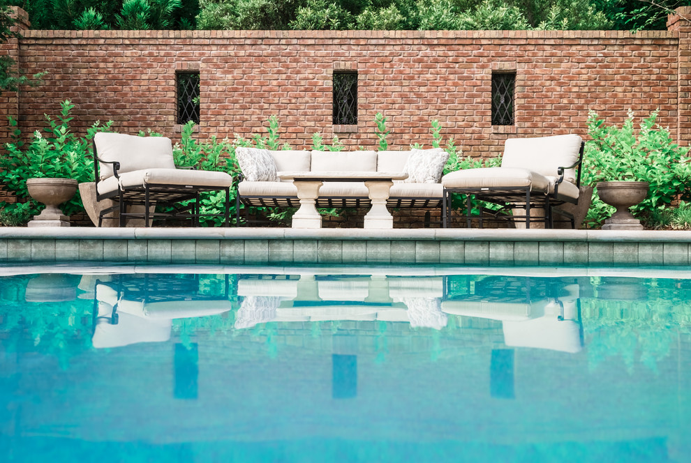 Immagine di una grande piscina naturale eclettica personalizzata dietro casa con una vasca idromassaggio e pavimentazioni in pietra naturale