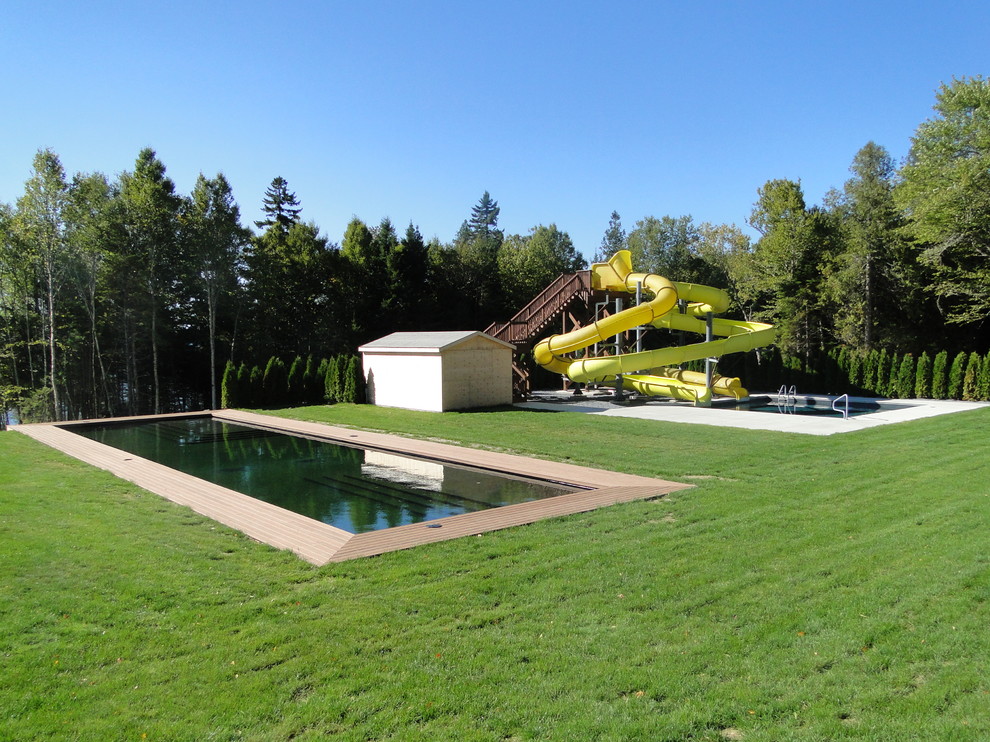 Foto de piscina con tobogán alargada actual extra grande rectangular en patio trasero con entablado