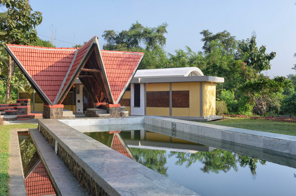 Diseño de piscina natural de estilo de casa de campo extra grande rectangular en patio delantero con paisajismo de piscina y adoquines de piedra natural