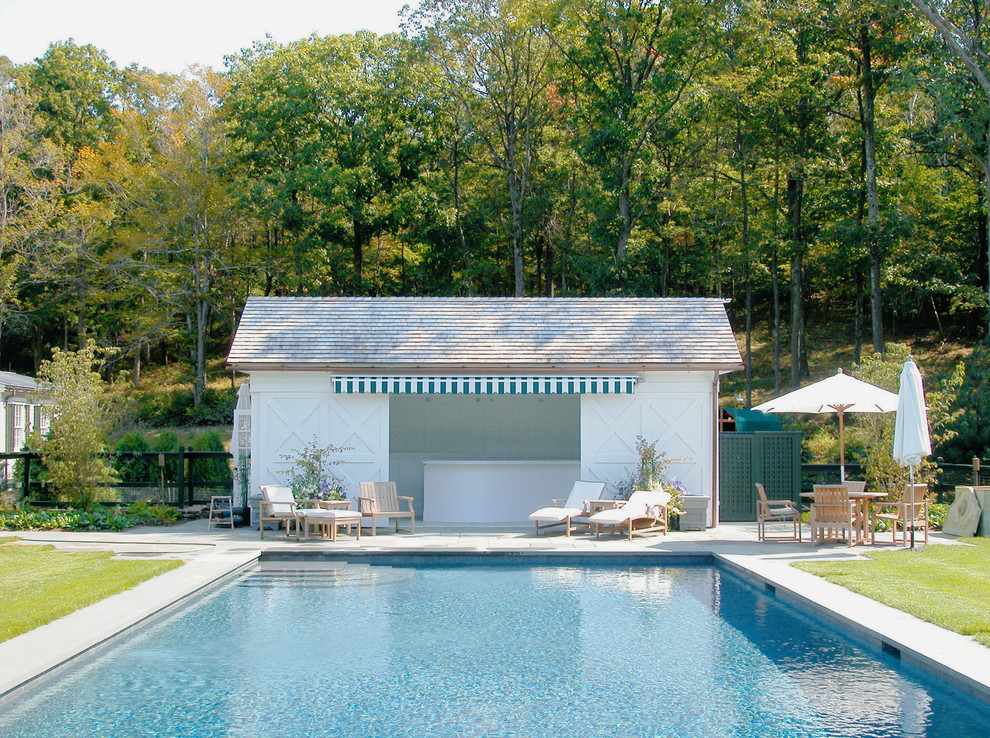 Rural back rectangular swimming pool in New York with a pool house.