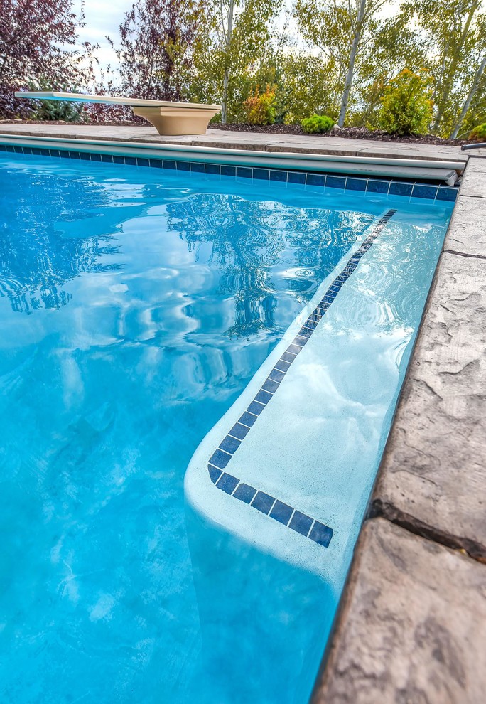 Uriger Pool hinter dem Haus in rechteckiger Form mit Pflastersteinen in Salt Lake City
