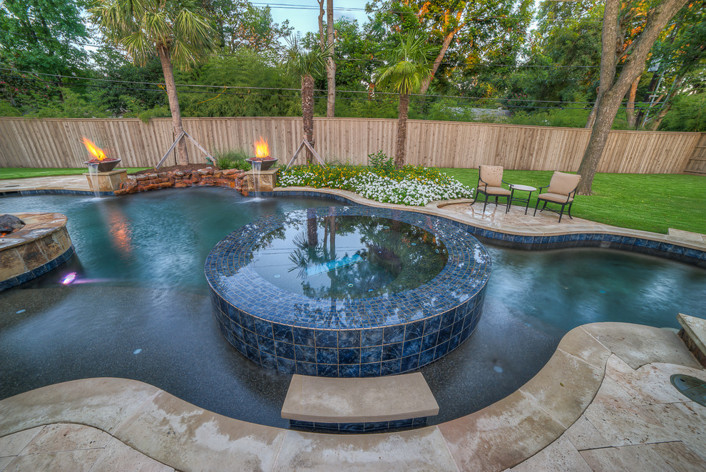 Immagine di una grande piscina tropicale a "C" dietro casa con una vasca idromassaggio e piastrelle