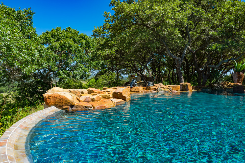 Imagen de piscinas y jacuzzis rústicos de tamaño medio a medida en patio trasero con adoquines de piedra natural