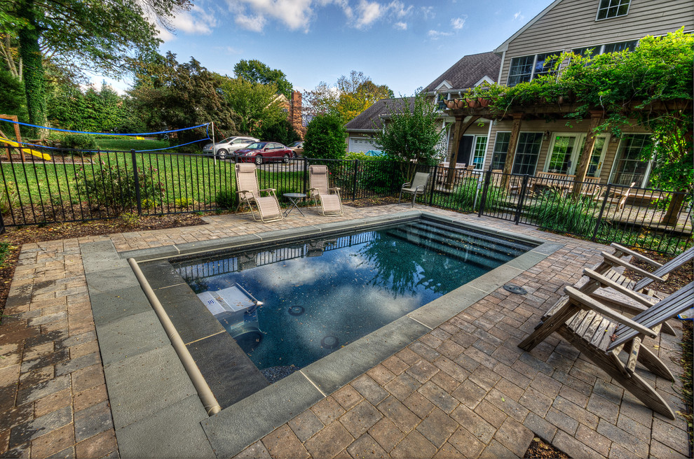 Foto di una piccola piscina monocorsia chic rettangolare dietro casa con pavimentazioni in mattoni