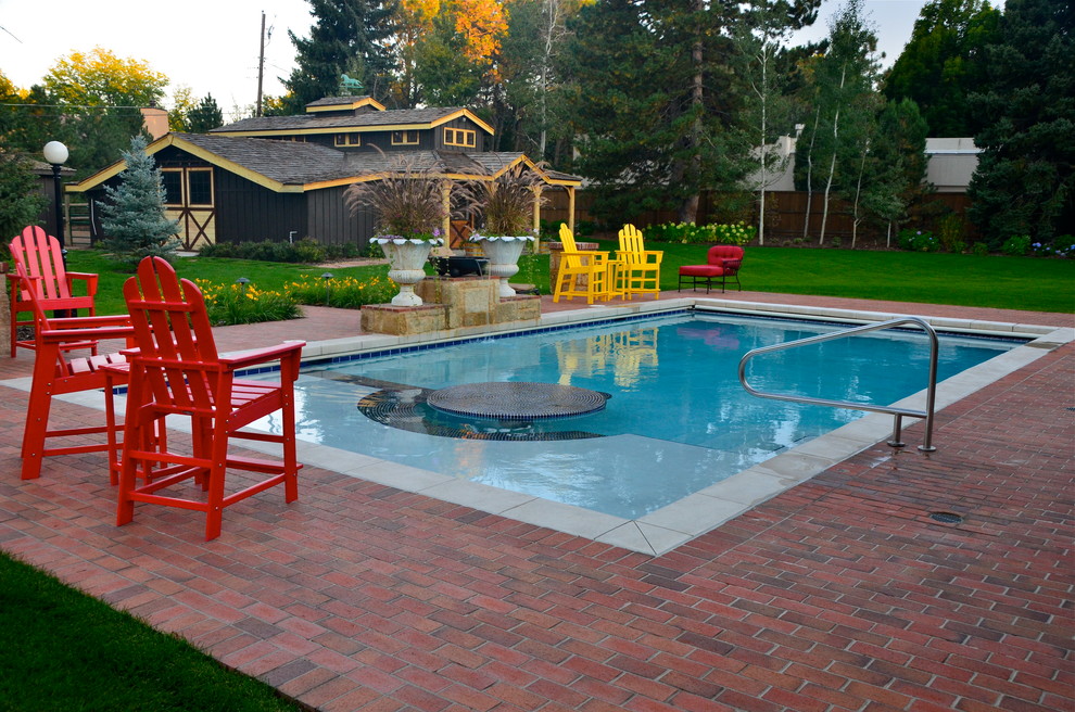 Large traditional back rectangular lengths swimming pool in Denver with brick paving.