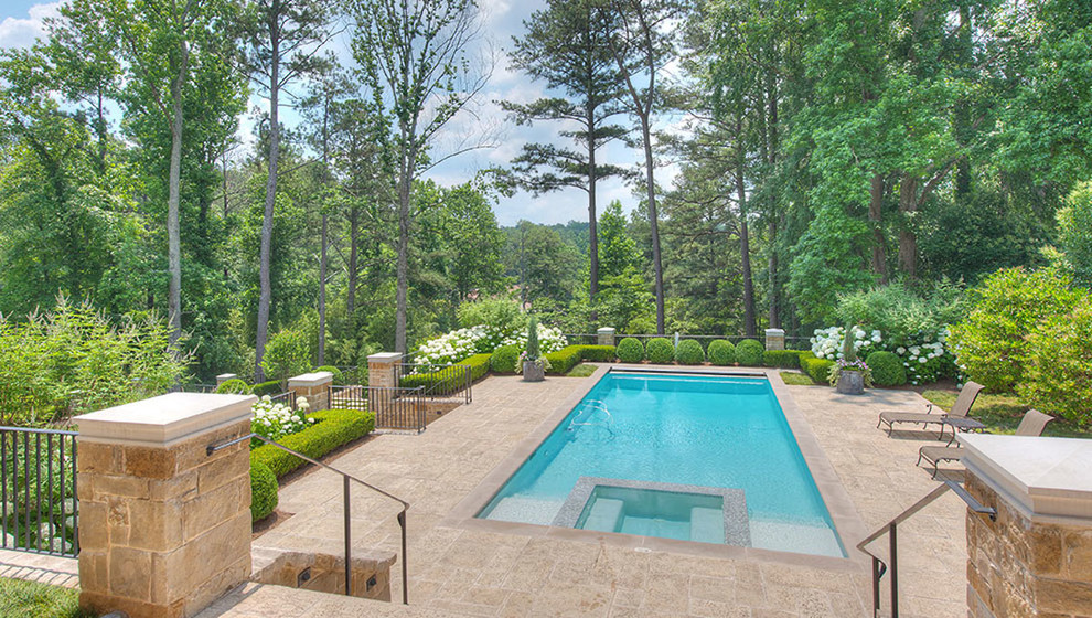 Immagine di una grande piscina naturale classica rettangolare dietro casa con una dépendance a bordo piscina e pavimentazioni in pietra naturale