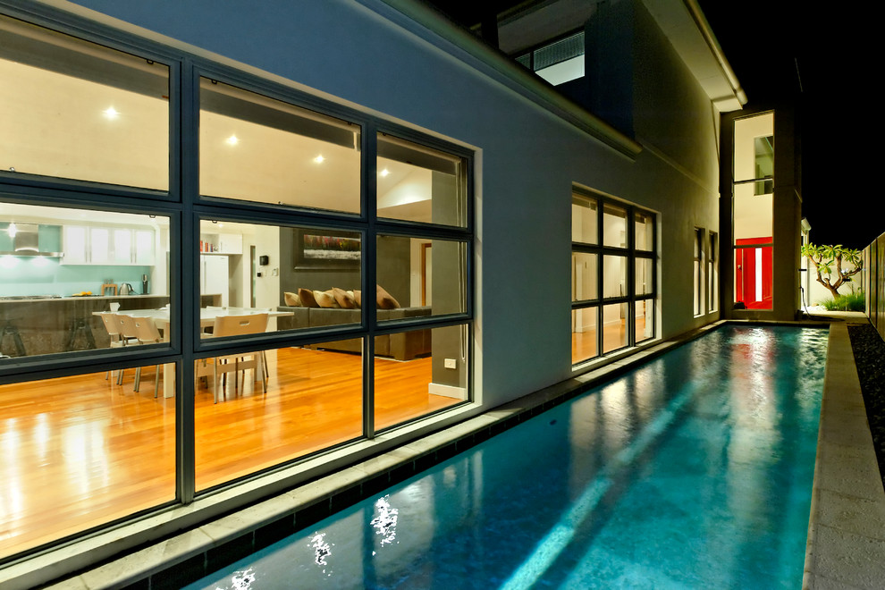 Imagen de piscina alargada contemporánea extra grande rectangular en patio lateral con adoquines de piedra natural