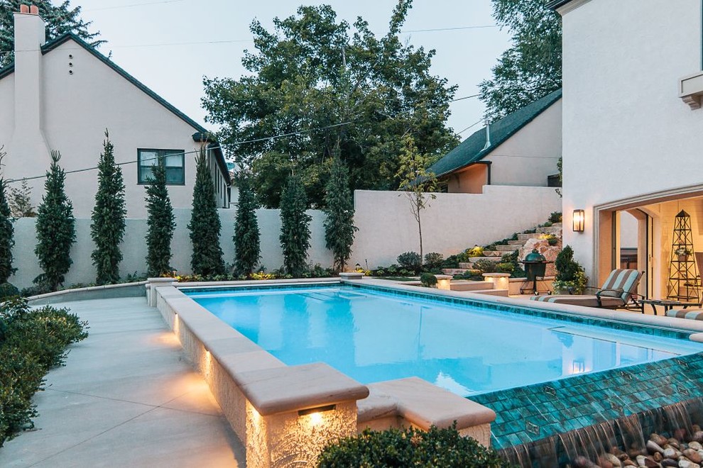 Medium sized classic rectangular infinity swimming pool in Salt Lake City with concrete slabs.