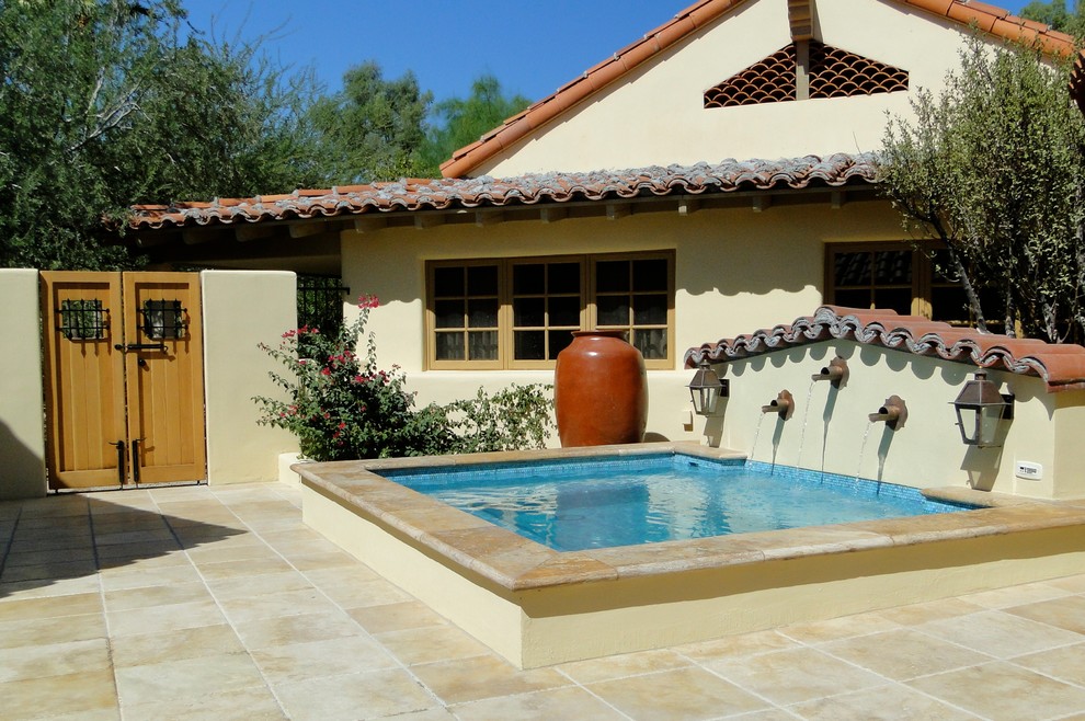 Tuscan courtyard tile hot tub photo in Phoenix