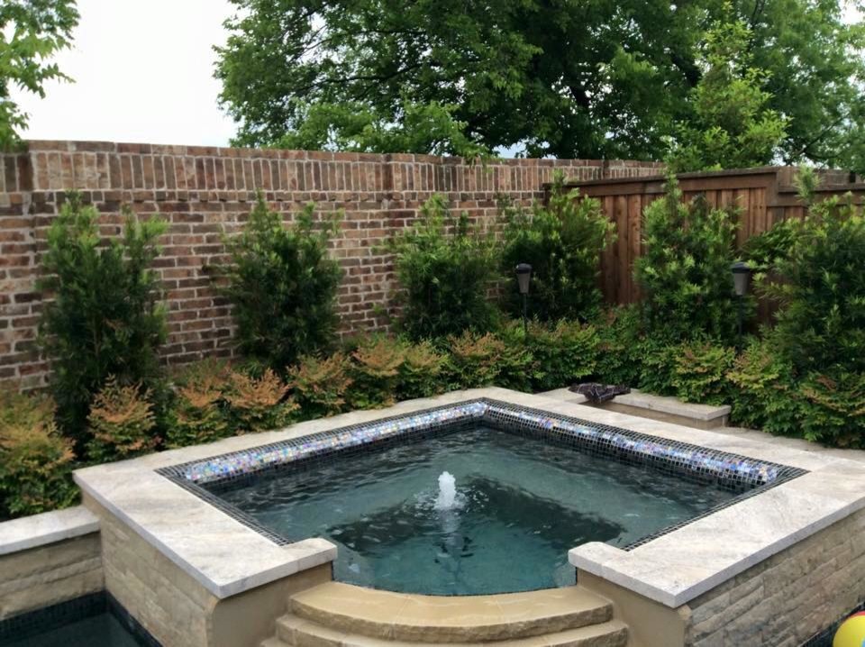 Ispirazione per una piscina naturale tradizionale a "L" di medie dimensioni e dietro casa con una vasca idromassaggio e pavimentazioni in pietra naturale