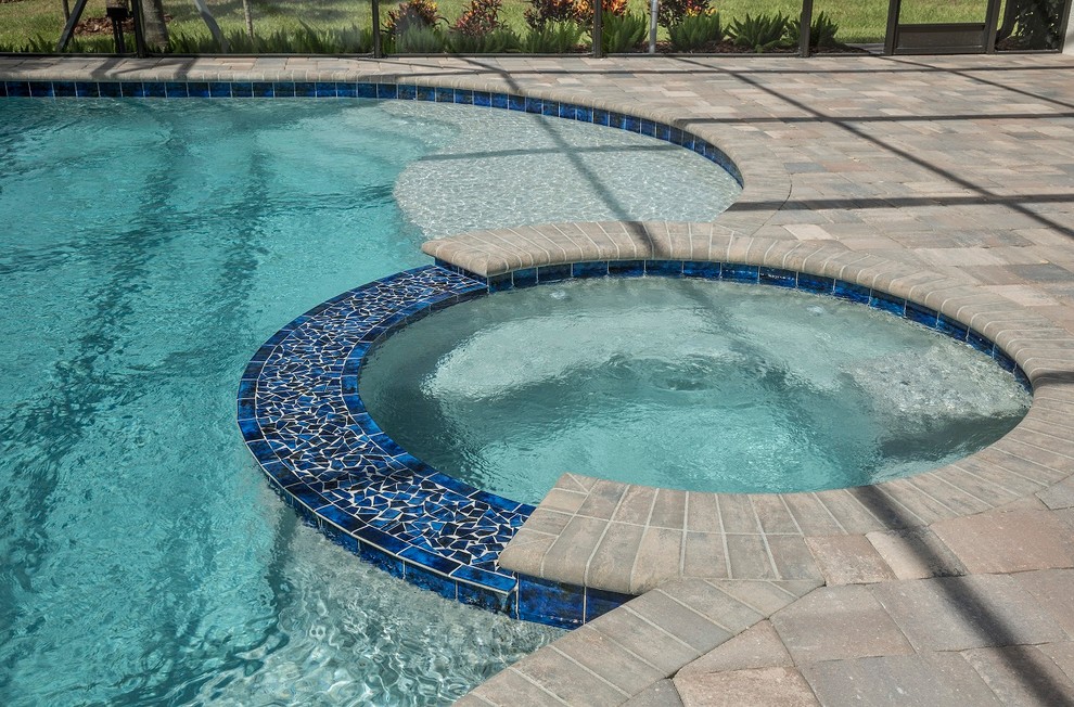 Ispirazione per una piscina minimal personalizzata di medie dimensioni e dietro casa con una vasca idromassaggio e pavimentazioni in cemento