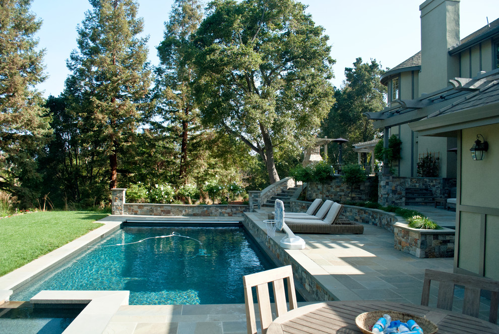 Idee per un'ampia piscina classica rettangolare davanti casa con pavimentazioni in pietra naturale