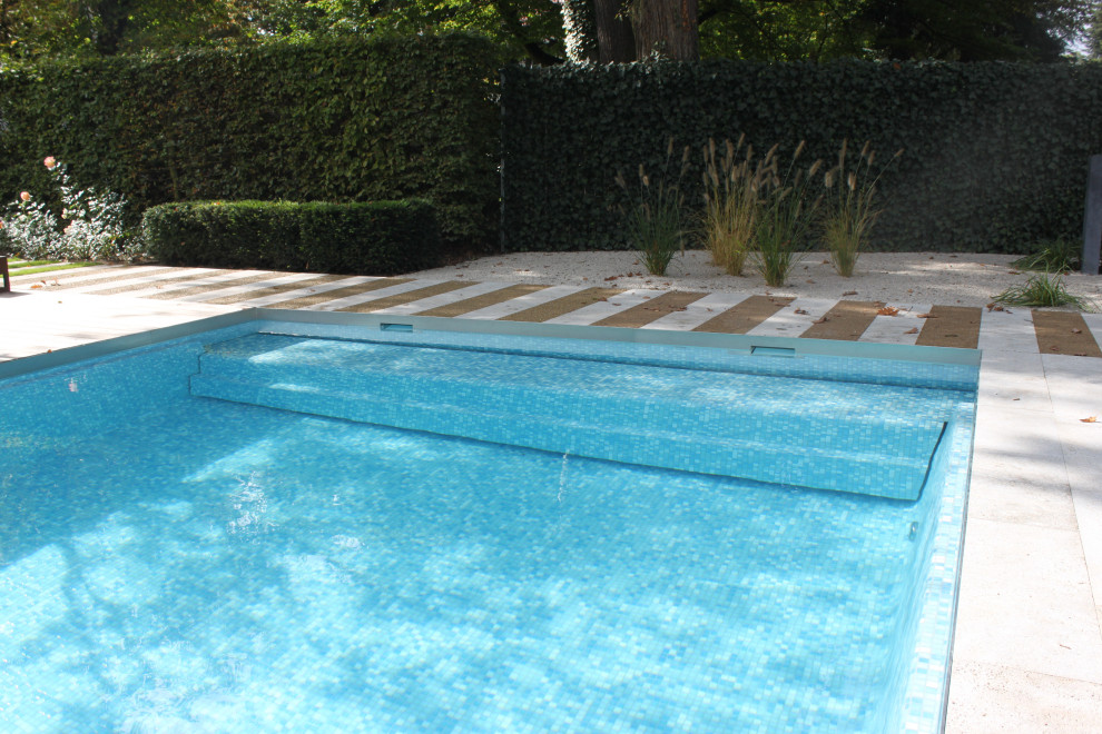Inspiration för en stor lantlig rektangulär pool längs med huset, med naturstensplattor