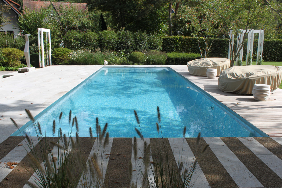 Idéer för att renovera en stor lantlig rektangulär pool längs med huset, med naturstensplattor