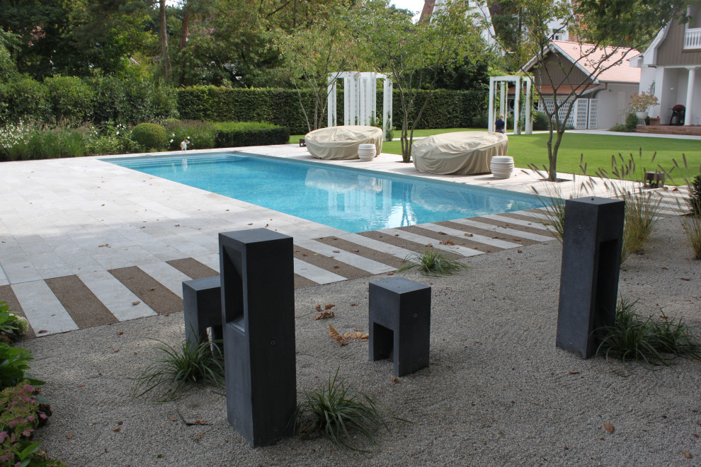 Foto de piscina campestre grande rectangular en patio lateral con adoquines de piedra natural