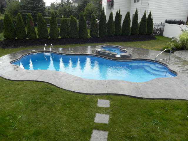 Стильный дизайн: большой естественный бассейн произвольной формы на заднем дворе в стиле кантри с покрытием из каменной брусчатки - последний тренд