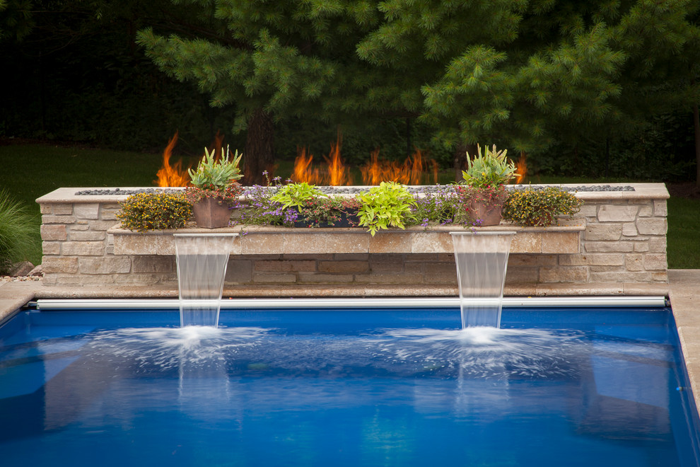 Foto de piscina con fuente contemporánea de tamaño medio rectangular en patio trasero con adoquines de piedra natural