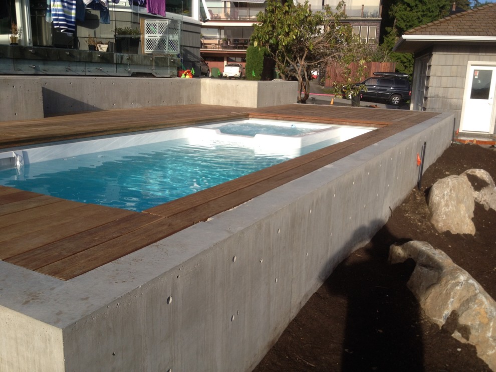 Aménagement d'une petite piscine naturelle et arrière contemporaine rectangle avec un bain bouillonnant et une terrasse en bois.