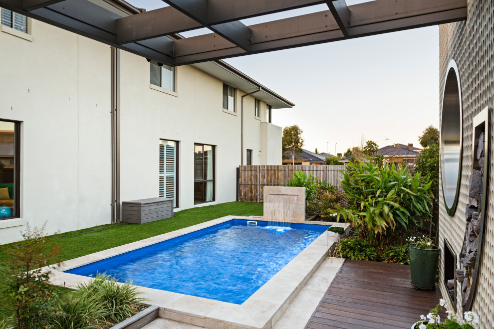 Immagine di una piscina naturale minimalista personalizzata di medie dimensioni e dietro casa con una dépendance a bordo piscina