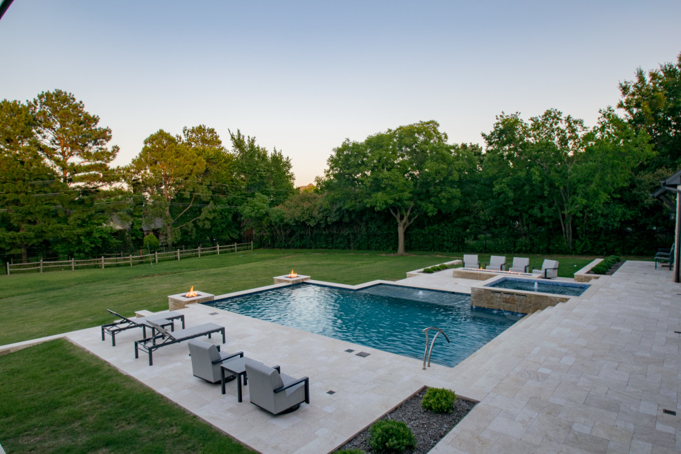 Ejemplo de piscina con fuente alargada campestre grande a medida en patio trasero con adoquines de piedra natural