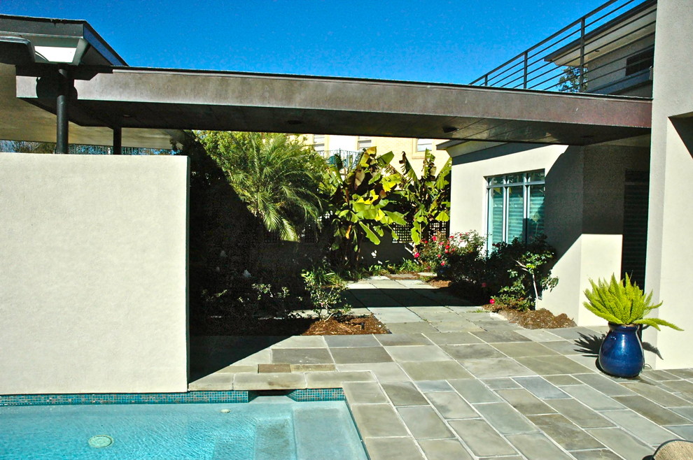 Ispirazione per una piscina minimalista rettangolare in cortile con pavimentazioni in pietra naturale