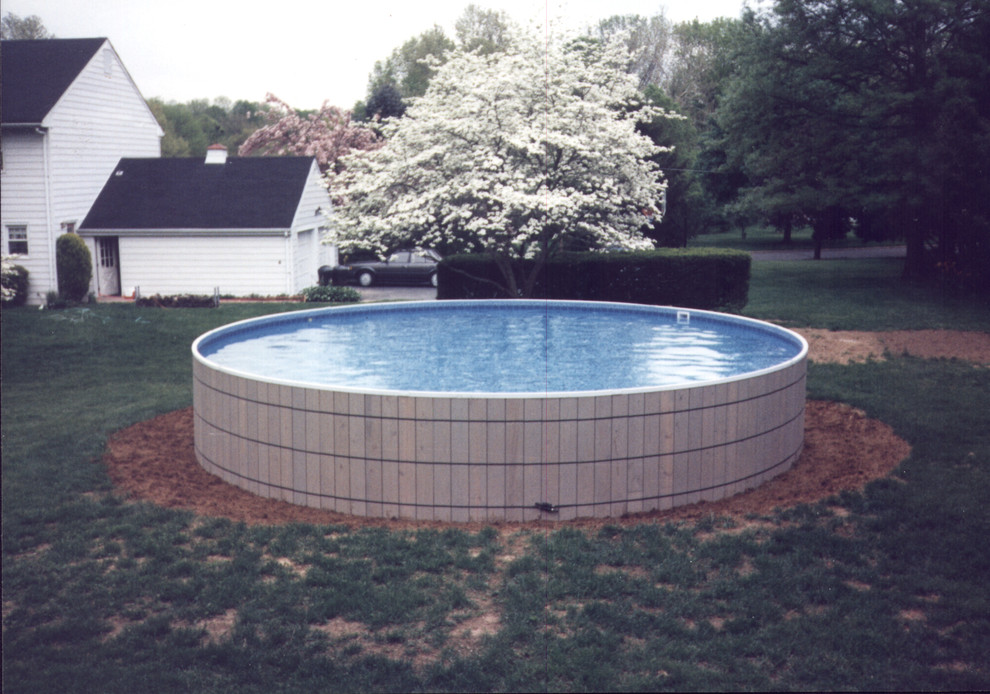 Inspiration for a mediterranean back round above ground swimming pool in New York with concrete paving.