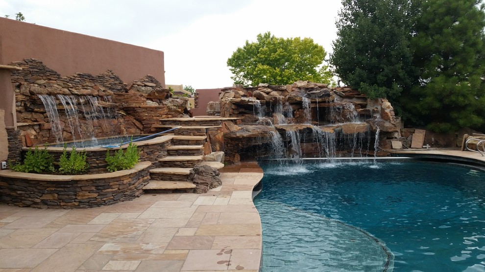 Foto de piscinas y jacuzzis naturales de estilo americano de tamaño medio a medida en patio trasero con adoquines de piedra natural