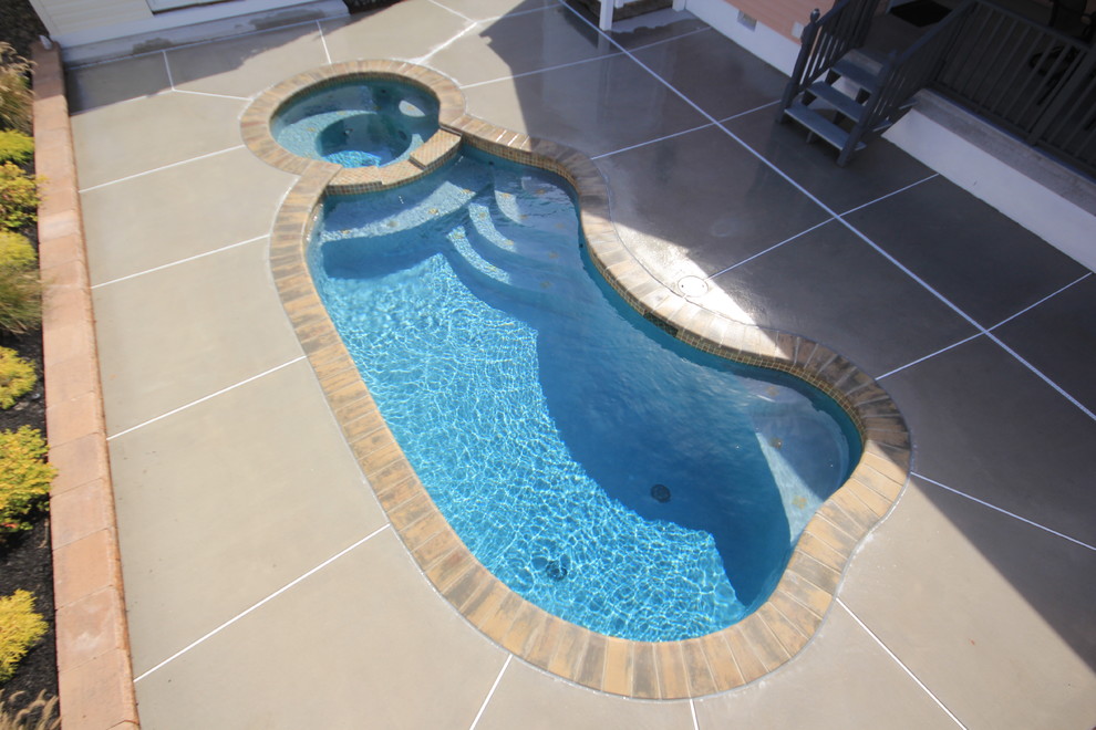 Modelo de piscina natural tropical pequeña a medida en patio trasero con adoquines de ladrillo