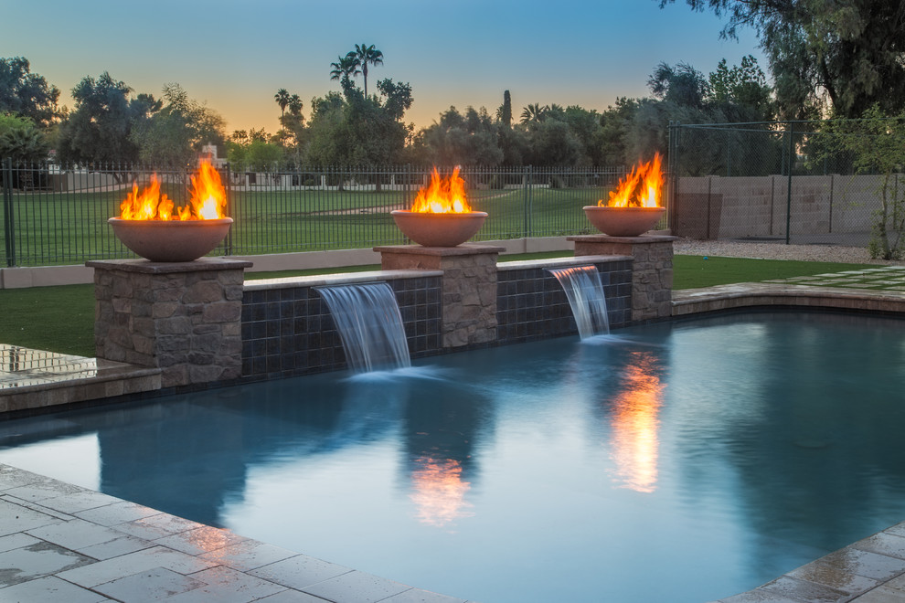 フェニックスにあるお手頃価格の広い地中海スタイルのおしゃれな裏庭プール (噴水、タイル敷き) の写真