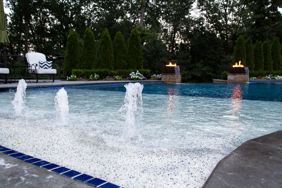 Пример оригинального дизайна: большой бассейн-инфинити произвольной формы на заднем дворе в современном стиле с фонтаном