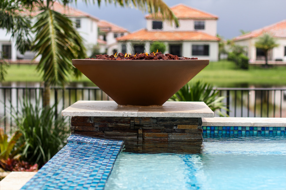 Foto di una piccola piscina fuori terra moderna personalizzata dietro casa con una vasca idromassaggio e pavimentazioni in pietra naturale