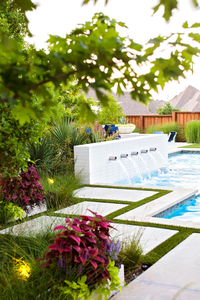 Ejemplo de piscina con fuente alargada bohemia a medida en patio trasero con adoquines de hormigón