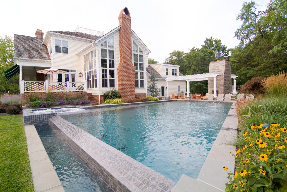 Идея дизайна: большой бассейн-инфинити на заднем дворе в классическом стиле с фонтаном