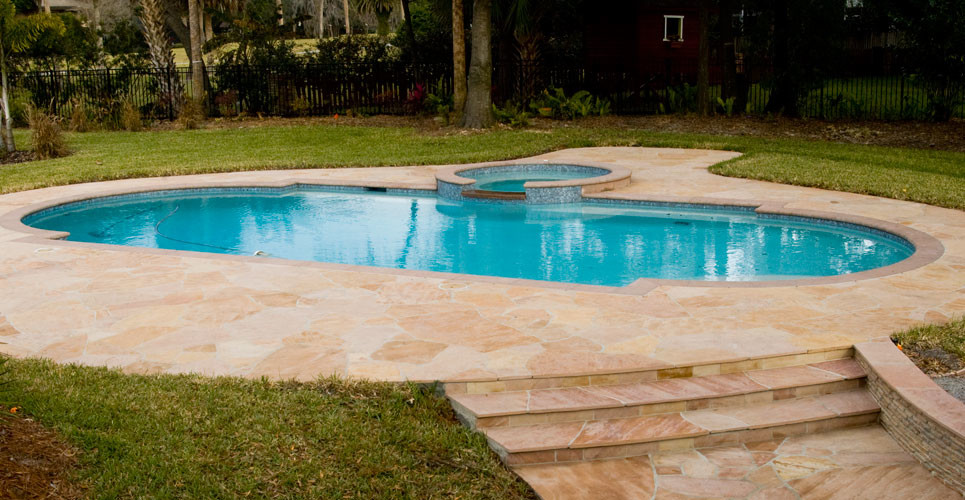 Foto di una grande piscina mediterranea personalizzata dietro casa con una vasca idromassaggio e pavimentazioni in pietra naturale