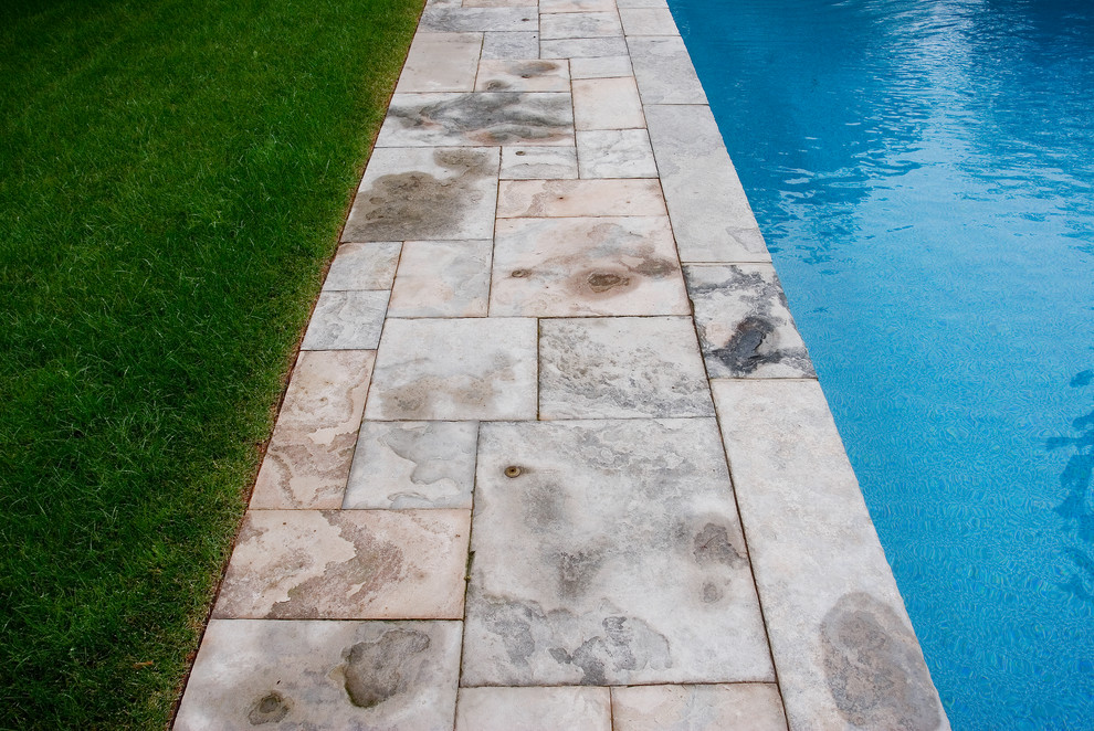 Idee per una piscina classica dietro casa con pavimentazioni in pietra naturale