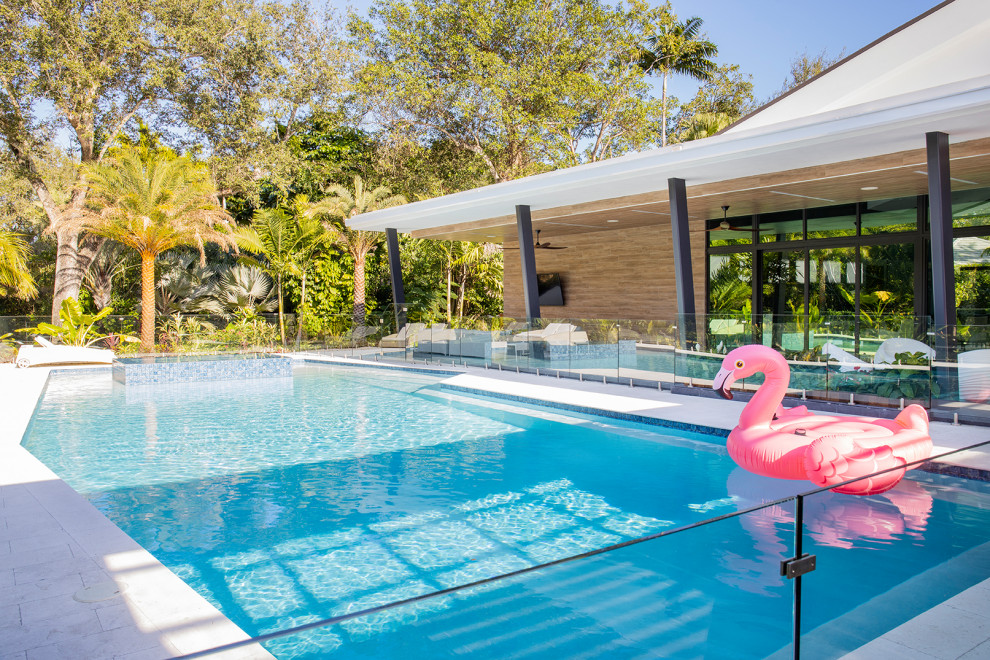 Imagen de piscinas y jacuzzis naturales contemporáneos grandes rectangulares en patio trasero con adoquines de piedra natural