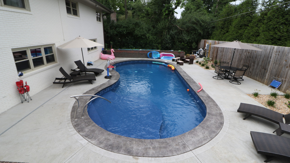 Foto på en stor medelhavsstil pool, med betongplatta