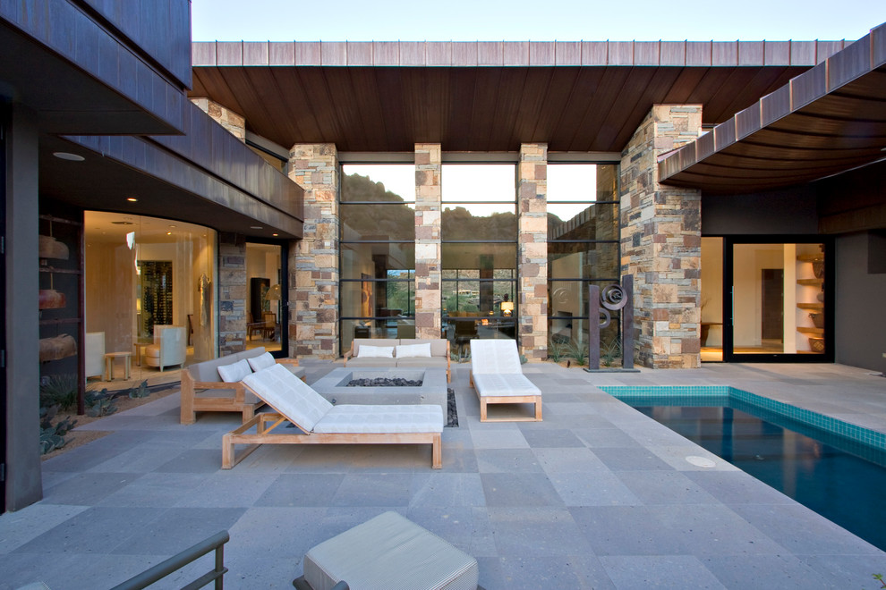 Foto de piscina alargada contemporánea de tamaño medio rectangular en patio trasero