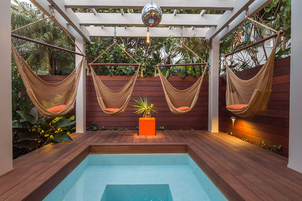 Cette photo montre une petite piscine exotique avec une terrasse en bois.