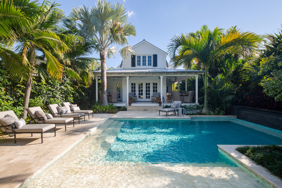 Beach style back l-shaped swimming pool in Miami with a pool house.