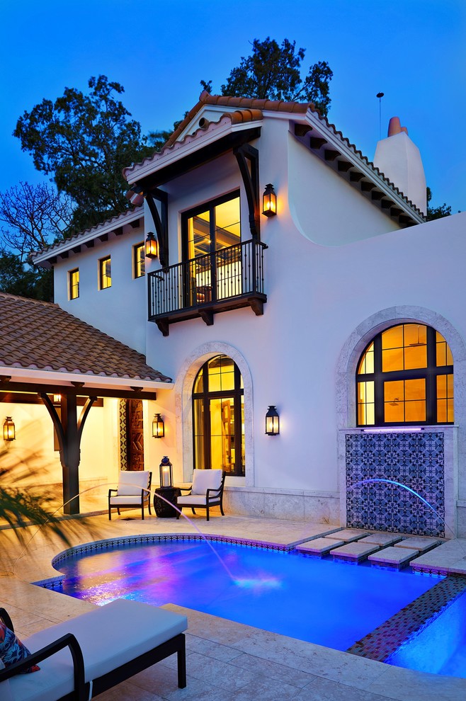 Immagine di una piscina naturale mediterranea personalizzata di medie dimensioni e dietro casa con fontane e piastrelle