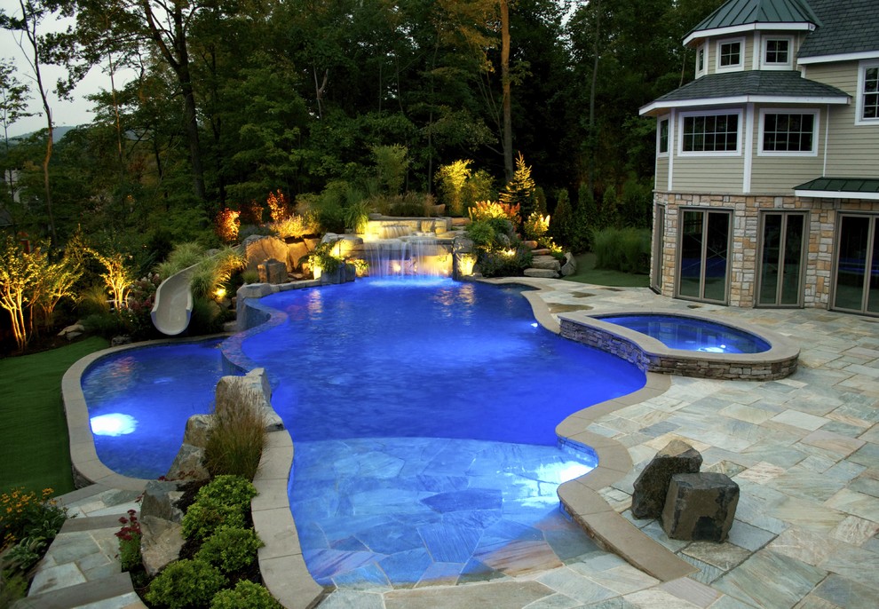 Пример оригинального дизайна: бассейн-инфинити среднего размера, произвольной формы на заднем дворе в морском стиле с водной горкой и покрытием из каменной брусчатки