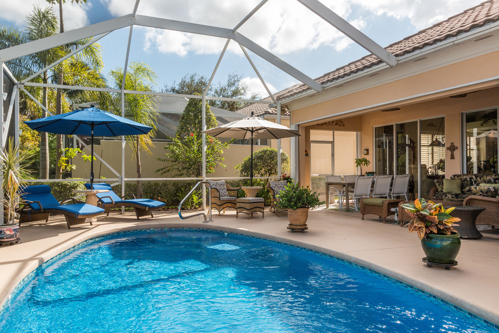 Imagen de casa de la piscina y piscina contemporánea de tamaño medio interior y redondeada con adoquines de hormigón