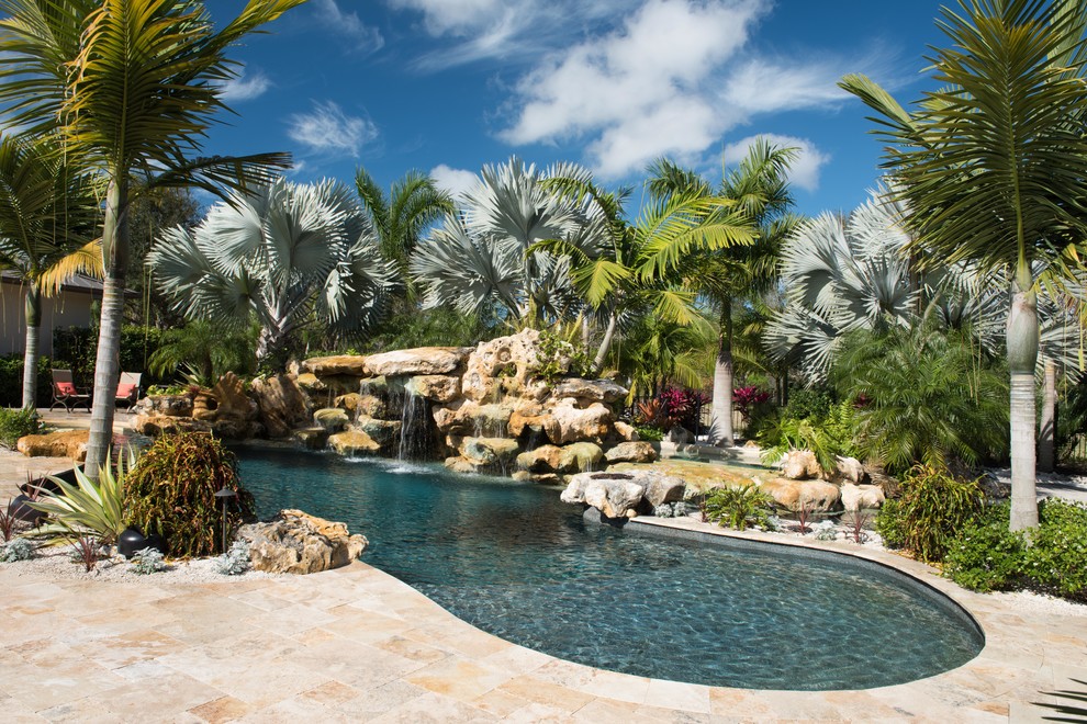 Idéer för mellanstora tropiska anpassad pooler på baksidan av huset, med en fontän och naturstensplattor